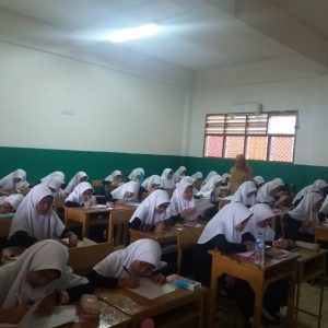 Santriwati konsentrasi mengerjakan soal ujian mid semester